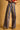 Amelti wide-leg pants with muted multicolor vertical stripes, high-rise waist and raw hems, front view.
Amelti striped wide-leg pants styled with brown loafers, side view.