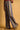 Amelti striped wide-leg pants styled with brown loafers, side view.