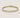 Gold bezel tennis bracelet with round clear stones, polished silver finish, secure clasp closure, and minimalist luxury jewelry styling on a warm light gray background.
