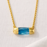 Austin Necklace close-up showing faceted blue bar pendant on gold chain.