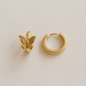 Avaia Huggie Earrings — gold plated butterfly huggie earrings on neutral linen background, polished and elegant jewelry by Matte.