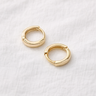 Awen Huggie Earrings – small polished gold huggie hoop earrings with a minimalist design, photographed on a soft neutral background.