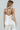 Model wearing the Lennon two-tone ivory satin cami with black faux-leather accents, back view.
