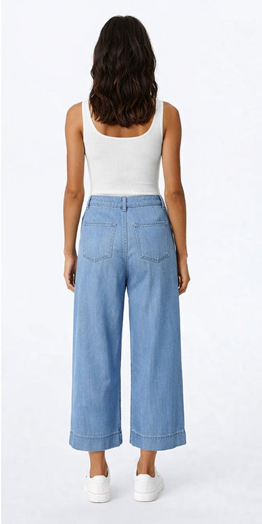 Relaxed wide-leg Tencel pants in light blue with natural fluid movement, shown in soft studio lighting on a model. Back view.