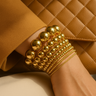 Bea Bracelet — mirrored beaded stretch bracelet shown in gold finishes, layered on wrist, polished and reflective by Matte.