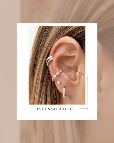 Close-up of an ear wearing a Potenza ear cuff with additional earrings on a neutral background