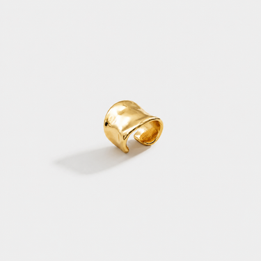 Gold ear cuff on a light gray background