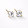 Biela Stud Earrings gold version close-up showing round-cut clear zirconia stones set in gold prong setting on light neutral background with soft shadow