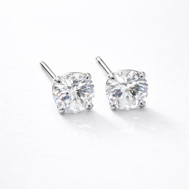 Biela Stud Earrings silver version close-up showing round-cut clear zirconia stones set in gold prong setting on light neutral background with soft shadow