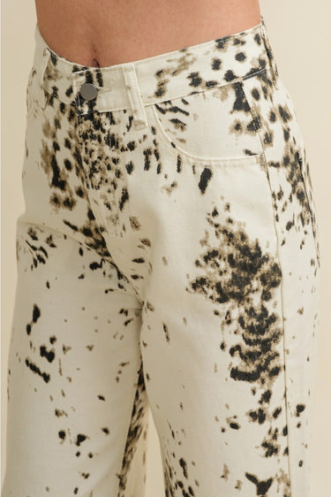Biz Pants close-up detail of ivory fabric with dark abstract splatter animal print pattern, highlighting texture, print placement, and modern statement design.