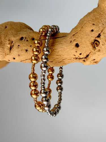 Two Blasco Bracelets in gold and silver beads wrapped on wood branch