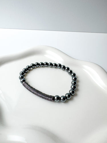 A black and silver beaded stretch bracelet displayed on a white surface by matte jewelry