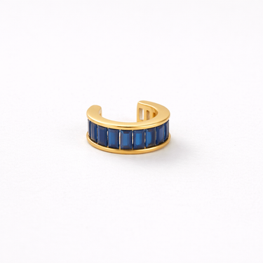 Gold ear cuff with blue stones on a white background