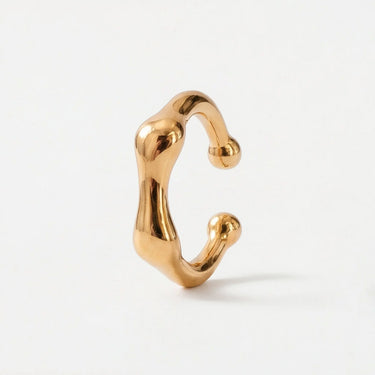 Bone Ear Cuff in glossy gold featuring an abstract molten-inspired shape with rounded sculptural edges and a modern open cuff design on a clean neutral background.