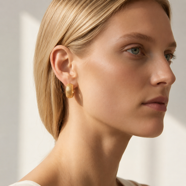 Brussels Huggie Earrings gold textured huggie hoops worn on model with polished finish, compact 13mm silhouette, and luxury minimalist styling.**

