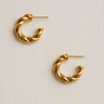 Calla Hoop Earrings — twisted gold plated hoops with sculptural shape on neutral linen background, polished and elegant jewelry by Matte.
