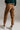 Back view of caramel relaxed fit trousers in 100% cotton with pockets and cuffed hem, casual everyday style