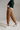 Close up of caramel relaxed fit cotton trousers showing waistband, button closure, and front pockets