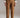 Front view of caramel relaxed fit cotton trousers with mid-rise waist and ankle length, styled with sneakers and green sweater