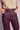 Close up of chocolate brown faux leather wide leg trousers with button closure and front pockets, cropped length design