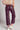 Back view of chocolate brown faux leather wide leg trousers with pockets and cropped length, styled with sneakers