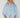 Model wearing the Corsica light-wash denim blouse with volume sleeves.
