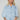 Model wearing the Corsica light-wash denim blouse with volume sleeves.
