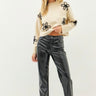 Model wearing black faux leather straight-leg pants with boots, front view.
