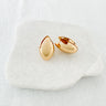 A pair of Doe gold-plated huggie earrings on a white surface