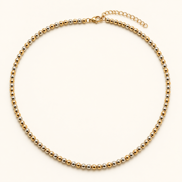 Eclat Necklace flat lay showing mixed metal beads, fine chain detail, and adjustable extender clasp.