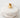 Gold ear cuff on a stack of white stones with a light gray background