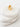 White stone with a gold ear cuff on a light gray background