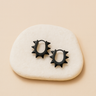 A pair of Elise  stainless steel Huggies earrings with a spike design, displayed on a white surface.