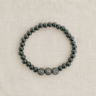 Emera Bracelet — polished hematite beaded bracelet with pavé crystal spheres on linen background, elegant stacking jewelry by Matte.