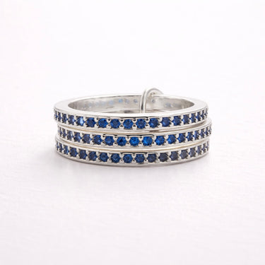 Ezer Ring multi-row pavé band ring with blue stones in silver finish on neutral background.