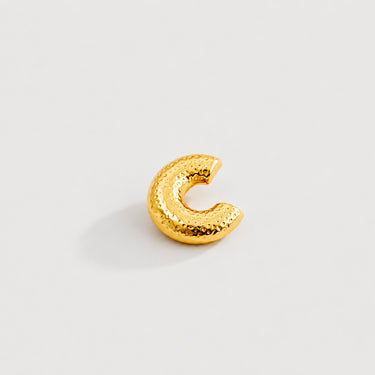 Fatima Ear Cuff in polished gold featuring a rounded dome silhouette with dotted textured detailing, designed as a modern sculptural statement ear cuff on a clean neutral background.