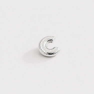 Fatima Ear Cuff in polished silver featuring a rounded dome silhouette with dotted textured detailing, designed as a modern sculptural statement ear cuff on a clean neutral background.