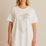Woman wearing Fierce T-Shirt Dress in white with metallic leopard print, casual relaxed fit.