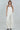 Model wearing the Lennon two-tone ivory satin cami with black faux-leather accents, tucked into white pants.