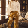 Full-length front view of Galicia Pant featuring mustard floral fabric, relaxed wide-leg fit, and cropped hem styled with black ballet flats.