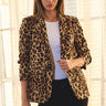 Close-up of women's leopard print blazer featuring structured shoulders, notched lapels, and ruched three-quarter sleeves.