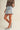 Girona Mini Short worn by model side view showing mini length and clean fit.
