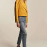 Woman posing in mustard yellow cropped coat with modern tailored style, perfect for fall layering