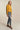 Woman posing in mustard yellow cropped coat with modern tailored style, perfect for fall layering