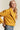 Woman wearing mustard yellow cropped coat with wide lapel, front view