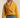 Side view of woman in mustard cropped coat with boxy silhouette