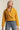 Side view of woman in mustard cropped coat with boxy silhouette
