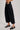 Side view of High-Rise Pleated Culotte Pants in black with wide leg silhouette and pleated design