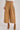 Person wearing tan wide-leg pants with a white background. Close-up of High-Rise Pleated Culotte Pants in taupe showing pleated front and flap pockets – cropped look