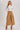 Model wearing High-Rise Pleated Culotte Pants in taupe, wide-leg cropped trousers with pleated design, styled with white ribbed turtleneck and suede ankle boots
